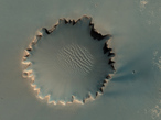 Der Victoria-Krater im Hochland Meridiani Planum. Er besitzt einen Durchmesser von etwa 800 Metern. Sedimentschichten und Felsen sind an seinem inneren Rand auszumachen. Letztere sind zum Teil sogar in das Zentrum des Kraters hinabgefallen. Der NASA Mars Rover Opportunity hat diesen Krater vor einigen Jahren besucht und untersucht.